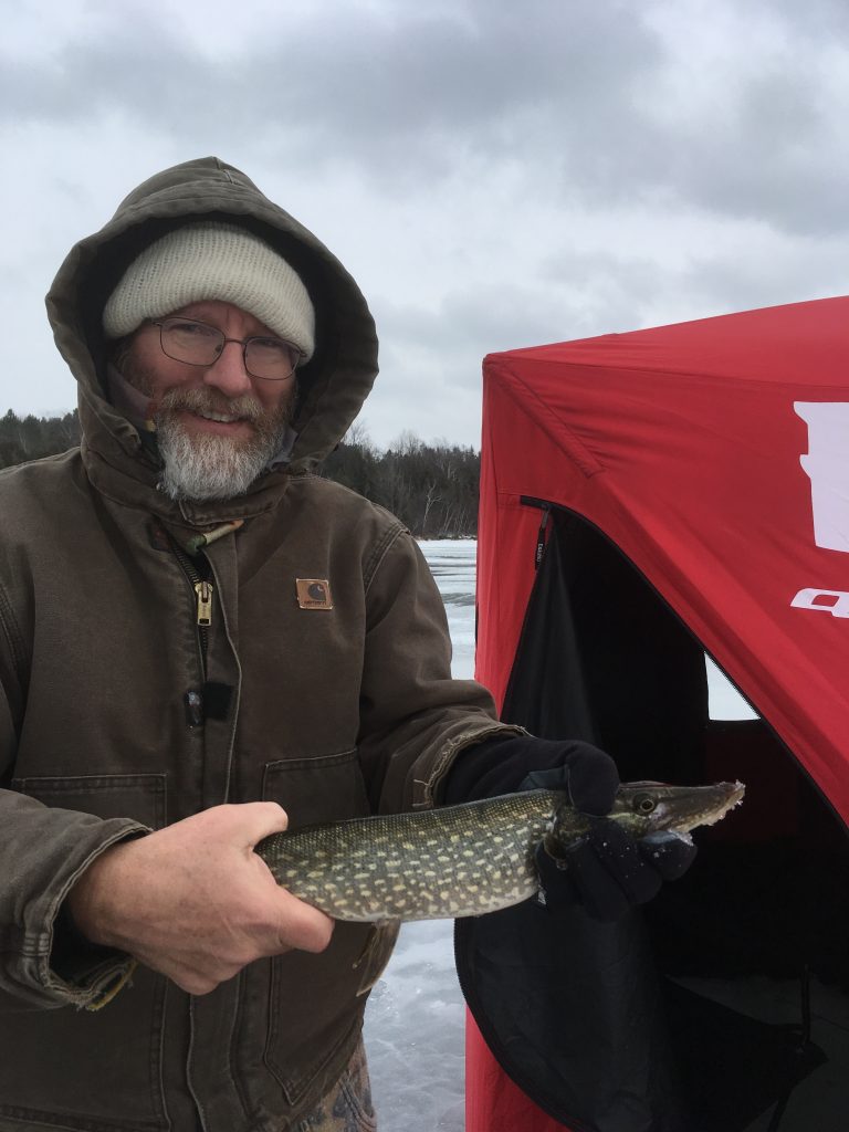 Charles holding a pike caught in Toronto